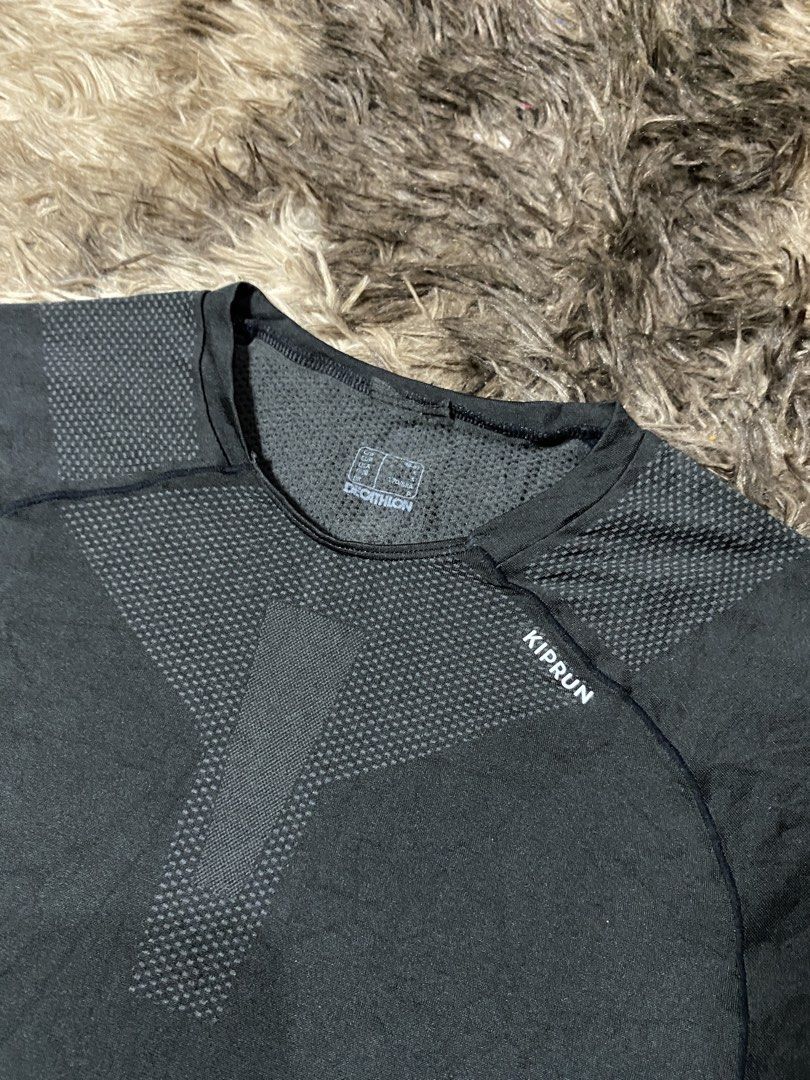 Kiprun Decathlon Running Shirt (Category: Activewear) located in General Santos City (Dadiangas). Submitted by killcloa2368358 (Listing ID 1438999824, Image 2). Description: - Decathlon Kiprun running shirt - Sleek, dark design - Short sleeves - Crew neck - Textured pattern - Features Kiprun logo - Includes Decathlon logo - Made of breathable, athletic material.