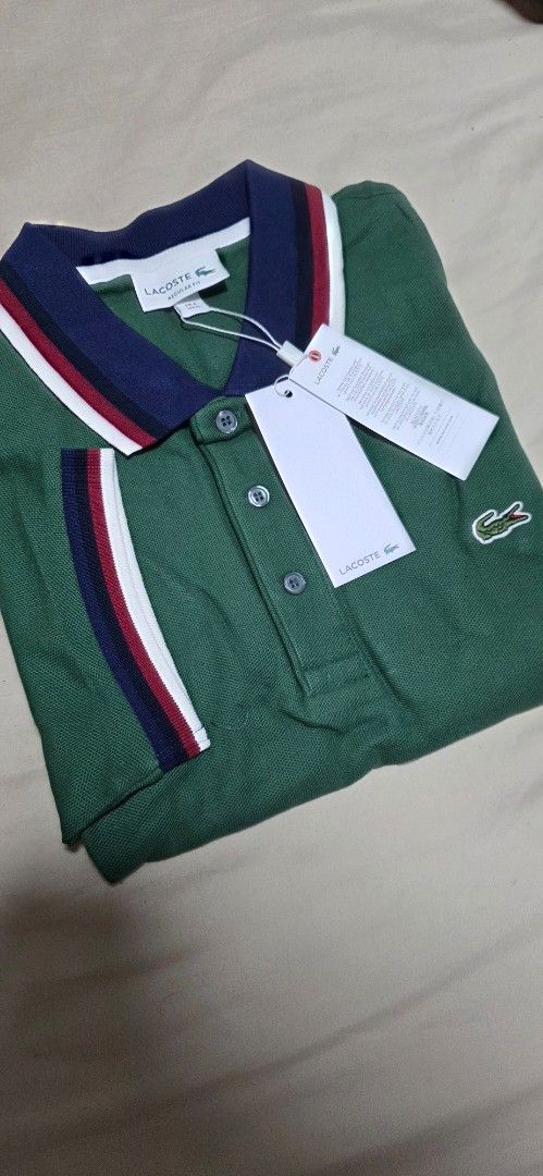 Lacoste Green Polo Shirt (Category: Tshirts & Polo Shirts ) located in Quezon City. Submitted by yGGGG (Listing ID 1439038233, Image 2). Description: - Brandnew Authentic Lacoste polo shirt - Color: Green - Classic collar with navy, red, and white stripes - Small Lacoste logo on chest - Striped sleeve cuffs - Includes original tags - Style: PH3461 - Size: Regular fit 4 Medium - Dimes: 20x27inches .