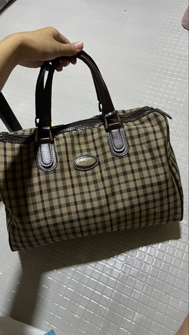 Lasserre Paris Handbag (Category: Luxury Bags & Wallets) located in Quezon City. Submitted by el_closets (Listing ID 1439010203, Image 2). Description: ARCHIVED LASSERRE PARIS VINTAGE CHECKERED BOSTON WEEKEND TRAVEL BAG MEASUREMENTS: 📏33.5 CM X 20 CM X 17 CM CONDITION USED 8/10 - Lasserre Paris handbag - Checkered pattern - Brown leather accents (handles & trim) - Zipper closure - Gold-toned logo .