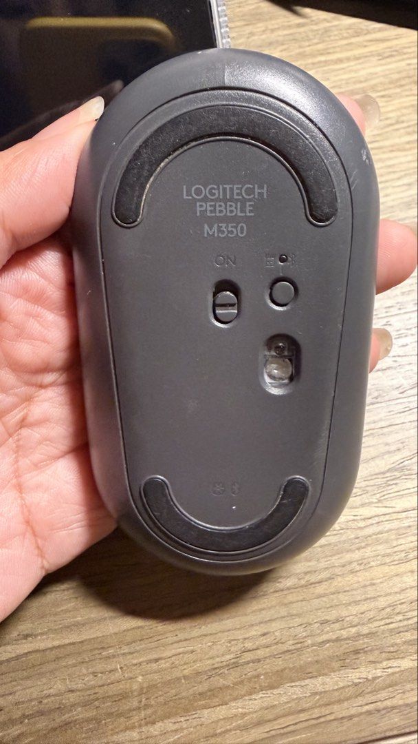 Logitech Pebble M350 Wireless Mouse (Category: Mouse & Mousepads) located in Manila. Submitted by eyaaa (Listing ID 1439027553, Image 2). Description: - Logitech Pebble M350 wireless mouse - Gray color - Sleek, oval design - Features a central scroll wheel and two buttons - On/off switch and button on the bottom - Model number: M350.
