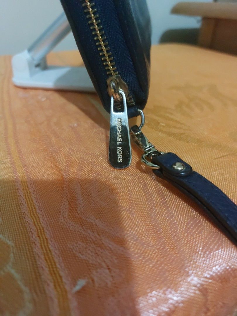 Michael Kors Continental Wristlet Navy Blue (Category: Wallets & Card holders) located in Las Pinas. Submitted by jmproperties (Listing ID 1438919572, Image 2). Description: - Authentic Michael Kors wristlet - Navy blue color - Zip-around closure - Multiple card slots - Clear ID window - Includes wrist strap - MK logo on front and zipper pull.