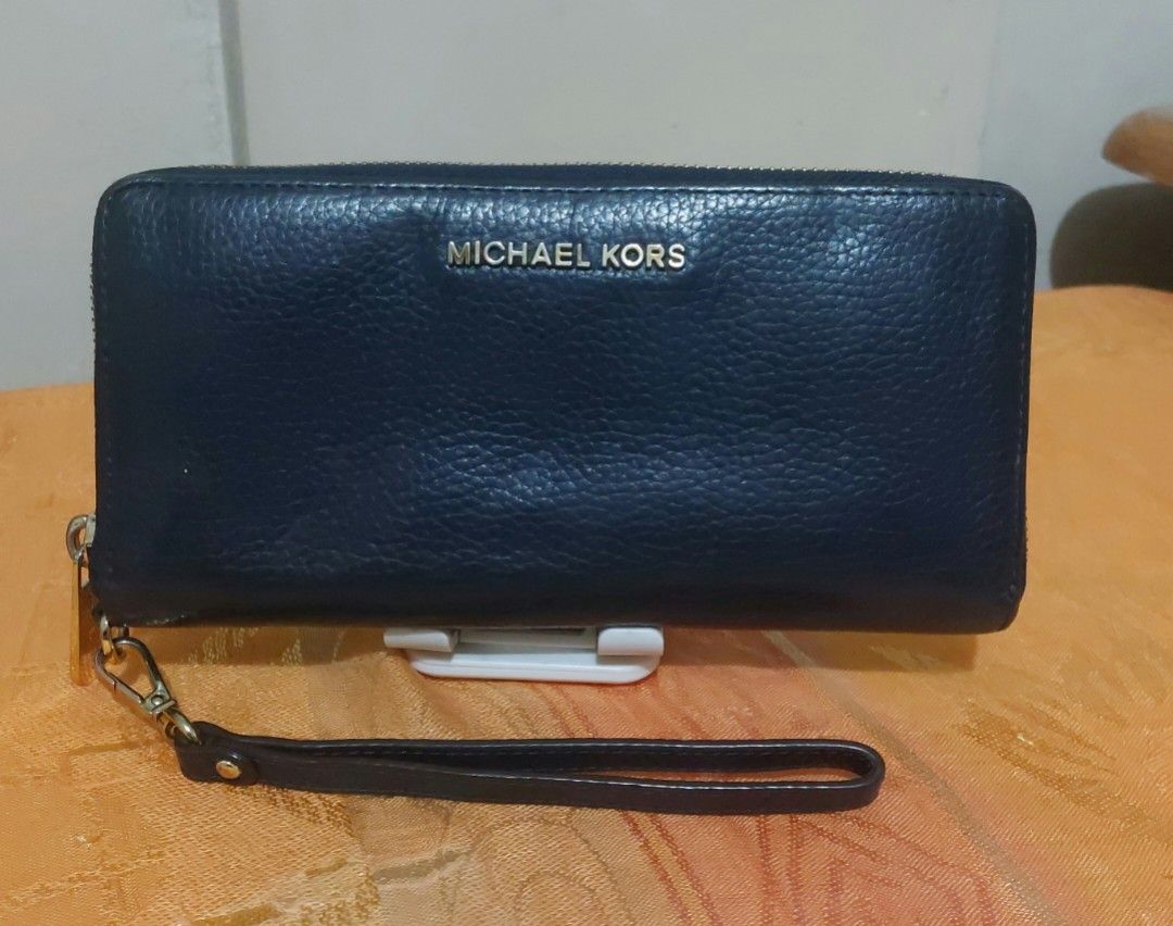 Michael Kors Continental Wristlet Navy Blue (Category: Wallets & Card holders) located in Las Pinas. Submitted by jmproperties (Listing ID 1438919572, Image 1). Description: - Authentic Michael Kors wristlet - Navy blue color - Zip-around closure - Multiple card slots - Clear ID window - Includes wrist strap - MK logo on front and zipper pull.