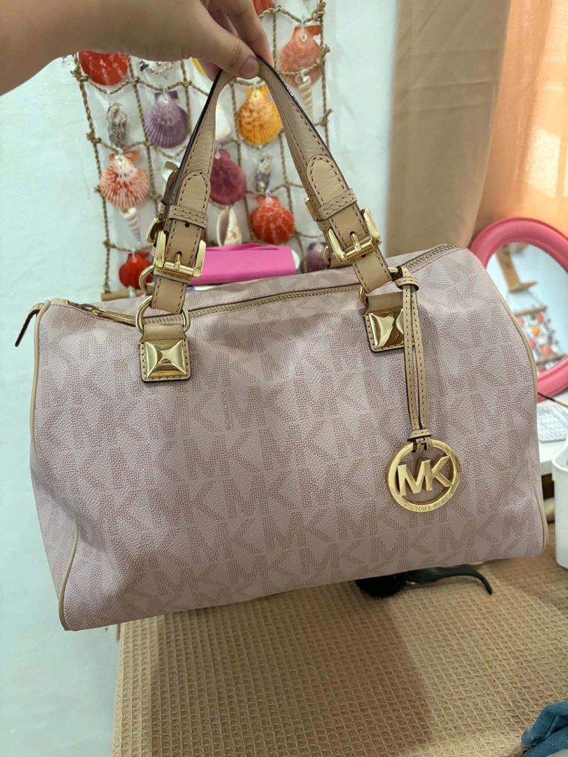 Michael Kors Pink Satchel Handbag (Category: Luxury Bags & Wallets) located in Calamba. Submitted by michCM (Listing ID 1438962071, Image 1). Description: - Michael Kors pink satchel handbag - Zip closure - Dual top handles - Gold-tone hardware - MK logo pattern - Detachable MK logo charm - Minor wear on corners - Not smooth Zipper .