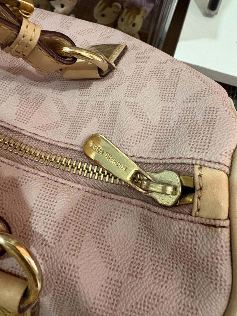 Michael Kors Pink Satchel Handbag (Category: Luxury Bags & Wallets) located in Calamba. Submitted by michCM (Listing ID 1438962071, Image 2). Description: - Michael Kors pink satchel handbag - Zip closure - Dual top handles - Gold-tone hardware - MK logo pattern - Detachable MK logo charm - Minor wear on corners - Not smooth Zipper .