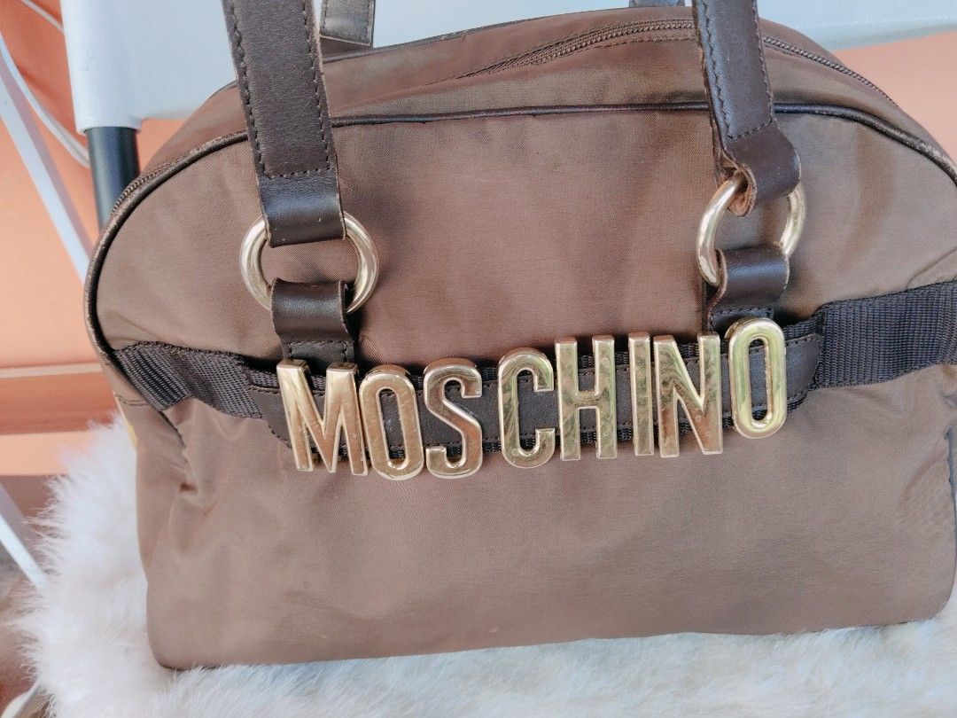 Moschino (Vintage) (Category: Luxury Bags & Wallets) located in Batangas. Submitted by kasualcornerph (Listing ID 1438967420, Image 2). Description: EXTERIOR: Minor darkening, slight scuffing on the pipeline, and snagging thread INTERIOR POCKET/COMPARTMENT: Minor white marks, and whitening HARDWARE: Minor discoloration, and scratches HANDLE: Minor crease, scuff, snagging thread, and color mark feel free to message for more information. Thank you 