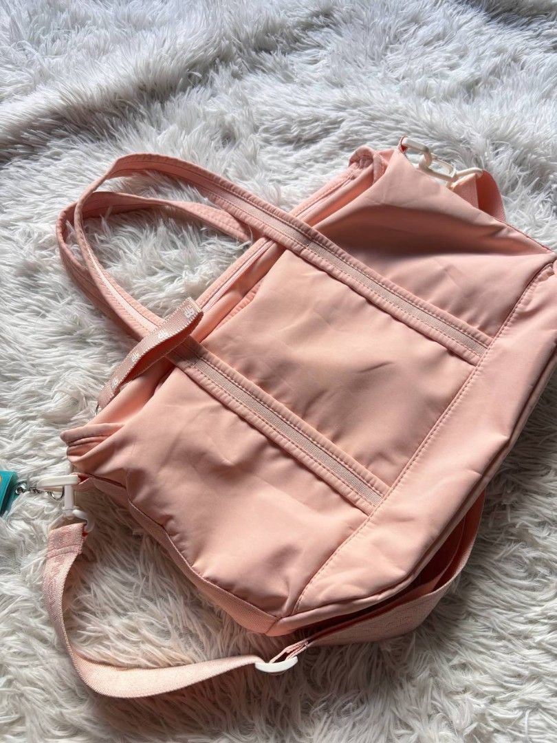 New Balance Pink Tote Bag (Category: Tote Bags) located in Catbalogan. Submitted by kristinapi (Listing ID 1438935675, Image 3). Description: Color rate: 10/10 Condition: EXCELLENT TO NEW - New Balance tote bag in a charming pink color. - Main compartment with secure zipper closure. - Includes an internal pocket for organization. - Versatile carrying options: adjustable shoulder strap and dual top handles. - Showcases the iconic New Balance logo.