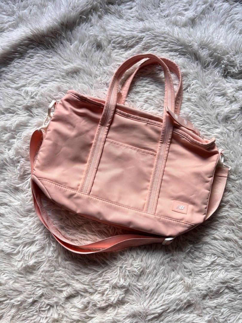 New Balance Pink Tote Bag (Category: Tote Bags) located in Catbalogan. Submitted by kristinapi (Listing ID 1438935675, Image 1). Description: Color rate: 10/10 Condition: EXCELLENT TO NEW - New Balance tote bag in a charming pink color. - Main compartment with secure zipper closure. - Includes an internal pocket for organization. - Versatile carrying options: adjustable shoulder strap and dual top handles. - Showcases the iconic New Balance logo.