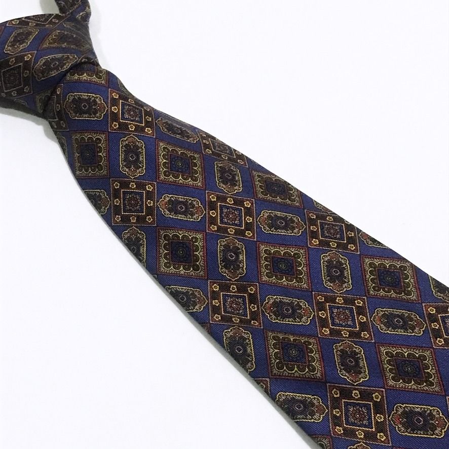 Philippe de Villiere Ornate Pattern Deep Navy Neck Tie (Category: Ties) located in Taguig. Submitted by retrogaze (Listing ID 1438917735, Image 2). Description: This Philippe de Villiere necktie is elegantly crafted from 100% silk, featuring a rich deep navy blue base with a smooth, luxurious finish. The tie is adorned with a detailed and ornate geometric pattern composed of miniature interlocking diamonds and medallions in a refined palette of c