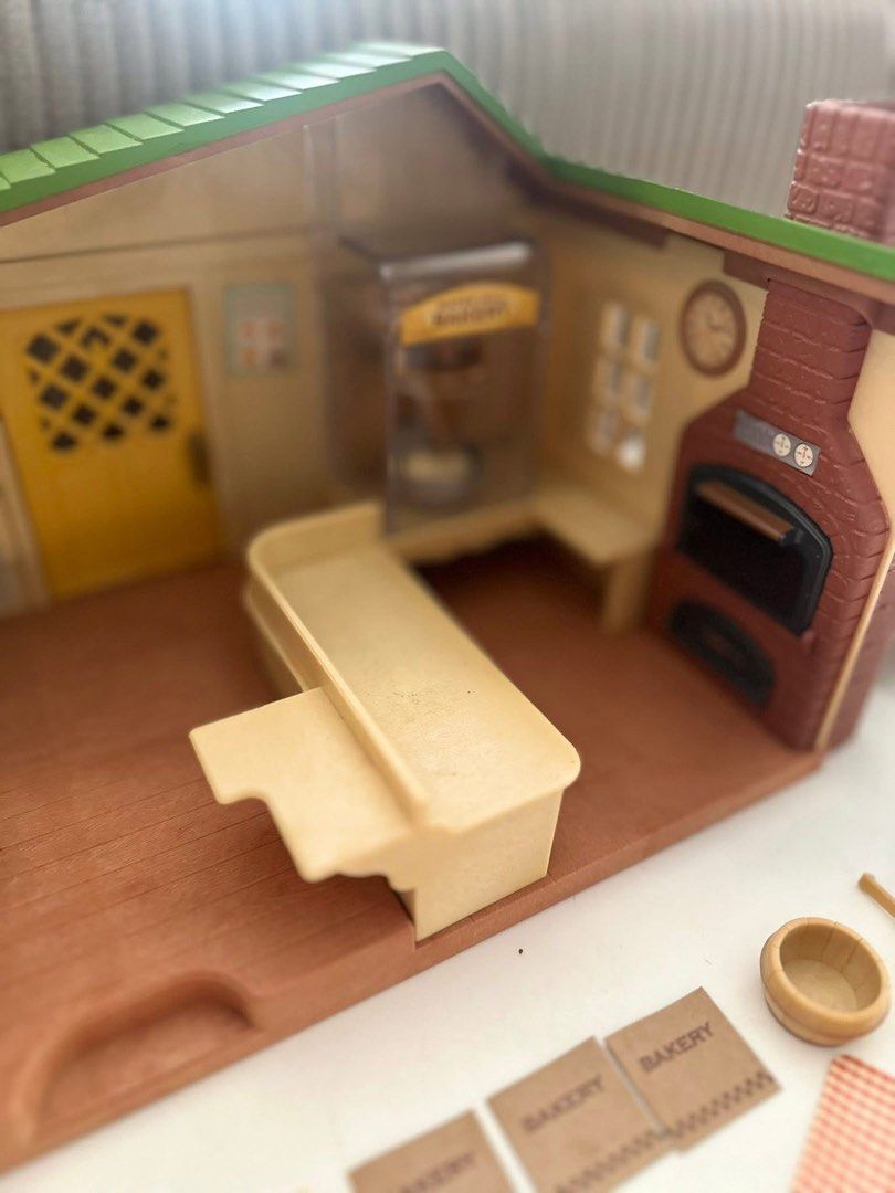 Sylvanian Families Waterside Bakery Playset (Category: Kids Toys) located in Kawit. Submitted by pinklilo (Listing ID 1438887735, Image 3). Description: - Sylvanian Families Waterside Bakery playset. - Includes bakery building, accessories, and figures. - Features a display case, oven, and counter. - Comes with various Sylvanian Families characters. - Box shows original packaging. - Suitable for children aged 4 and up..