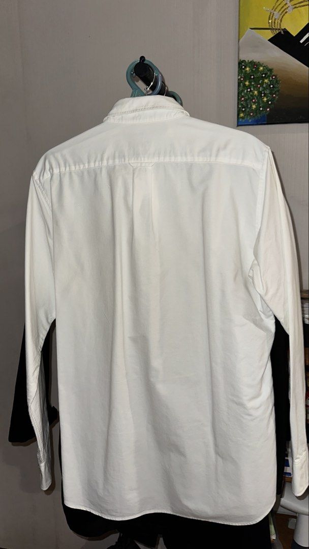 Uniqlo Slim Fit Button Down Shirt - White (Category: Tshirts & Polo Shirts ) located in Quezon City. Submitted by localthriftstore (Listing ID 1439009567, Image 2). Description: - Uniqlo button-down shirt - Color: White - Size: L - Fit: Slim - Features: Button-down collar, chest pocket - Sleeves: Long - Style: Classic, versatile - Occasion: Casual to semi-formal.