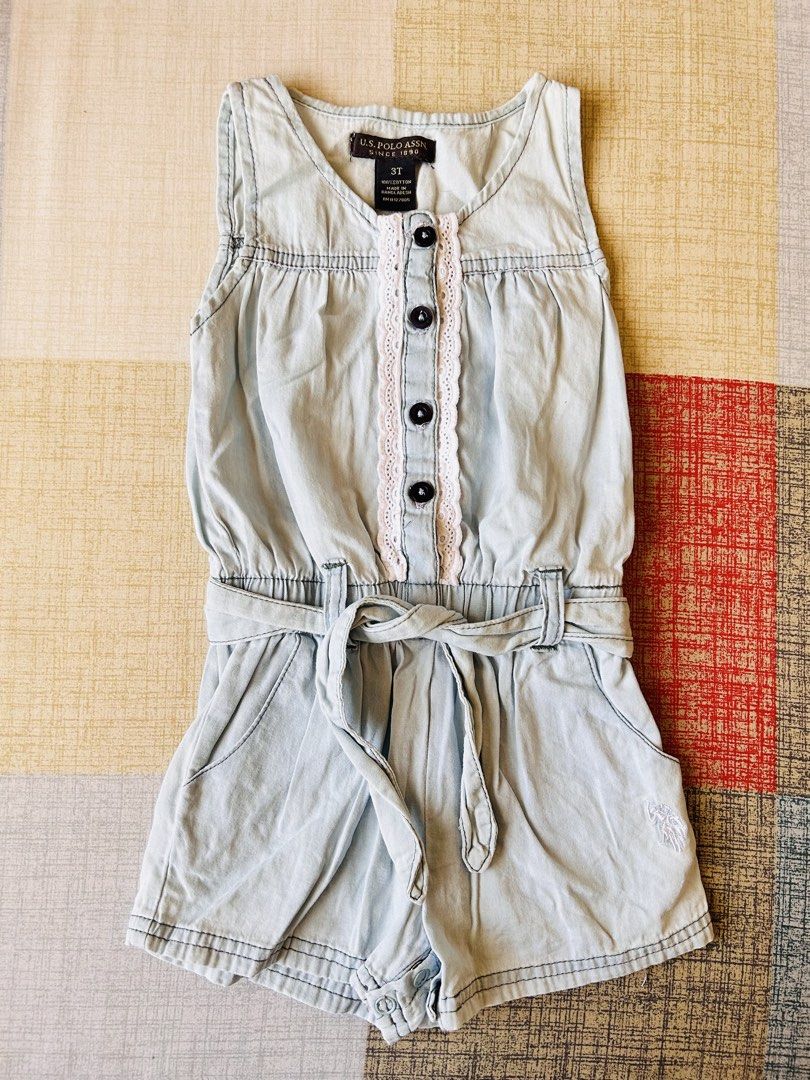 U.S. Polo Assn. Denim Romper 3T (Category: Babies & Kids Fashion) located in Santa Rosa. Submitted by lovedbydane (Listing ID 1438884892, Image 1). Description: Light blue denim romper from U.S. Polo Assn. Features a sleeveless design with a V-neckline, decorative buttons, and a waist tie. Includes pockets and a small logo detail. Size 3T. Fits 2-3t.