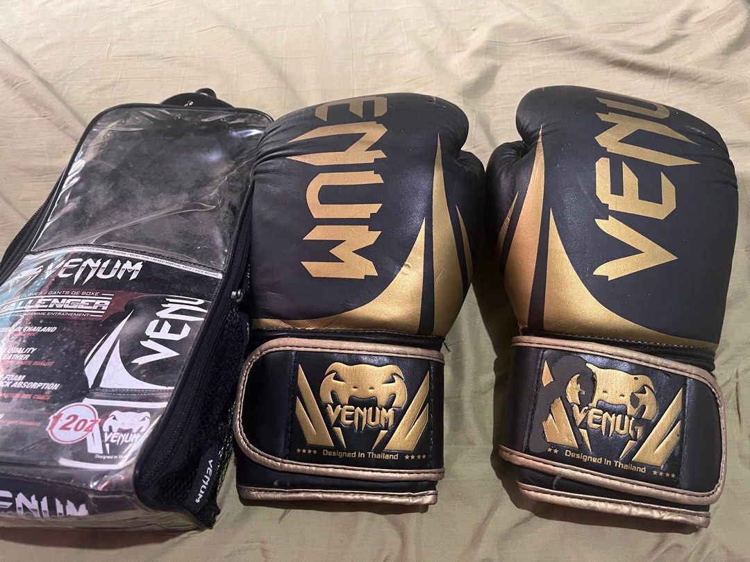 Venum Challenger 2.0 Boxing Gloves (Category: Combat Sports) located in Manila. Submitted by cleverhorse.ab90fe (Listing ID 1438999186, Image 1). Description: - Venum Challenger 2.0 boxing gloves - Stylish black and gold design - Comes with a convenient carrying bag - Authentic "Designed in Thailand" quality - Features the iconic Venum logo - 12 Oz.