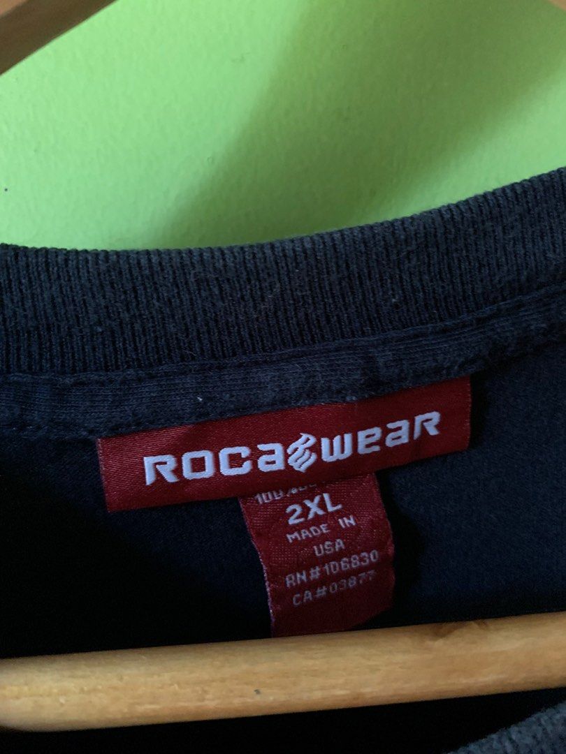 Vintage late 1990s Rocawear tee (Category: Tshirts & Polo Shirts ) located in Cagayan de Oro. Submitted by premium_thrifts (Listing ID 1438909168, Image 3). Description: Navy blue colorway. Good condition. Issues: slight crackprint, spot stains on print, and fades on collar - MEASUREMENTS: L32.5" x W25" 24.5" (shoulder to shoulder) 9.5" (sleeve length) Fits 2XL Add shipping fee (via JRS or J&T).
