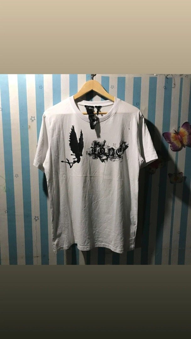 Vlone White Graphic T-shirt (Category: Tshirts & Polo Shirts ) located in Caloocan City. Submitted by thriftjohn (Listing ID 1438882529, Image 1). Description: - Vlone T-shirt - Front graphic: angel and "Lone" - Back graphic: large "V" design - Crew neck - Short sleeves - Size: Not specified.
