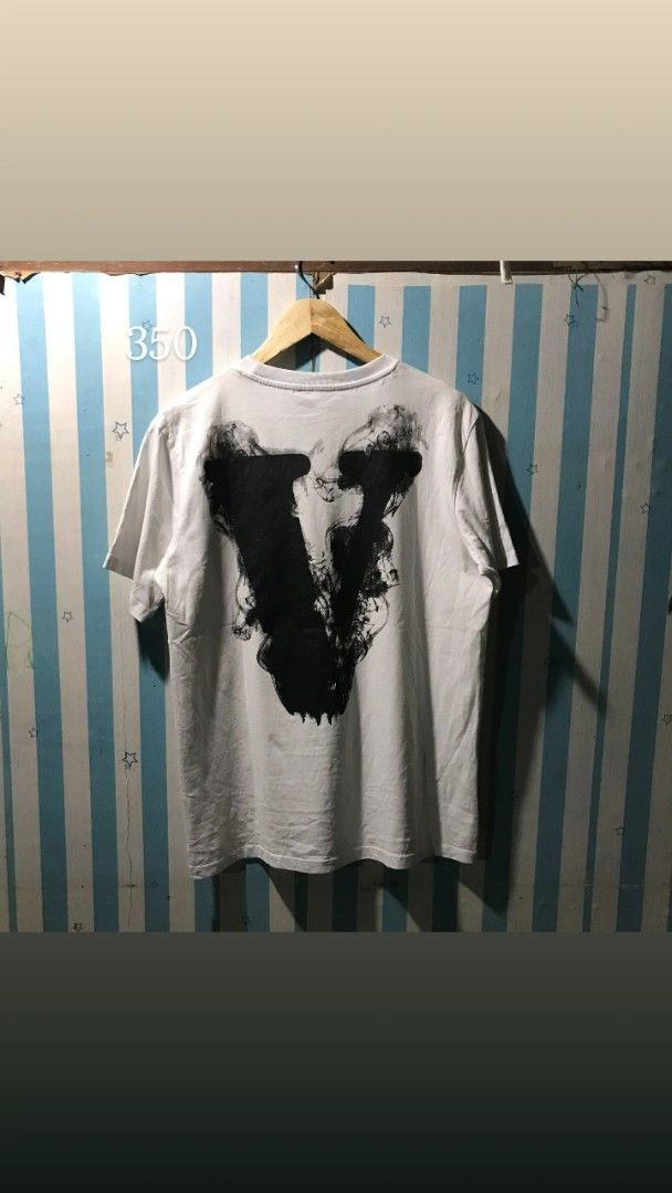 Vlone White Graphic T-shirt (Category: Tshirts & Polo Shirts ) located in Caloocan City. Submitted by thriftjohn (Listing ID 1438882529, Image 2). Description: - Vlone T-shirt - Front graphic: angel and "Lone" - Back graphic: large "V" design - Crew neck - Short sleeves - Size: Not specified.