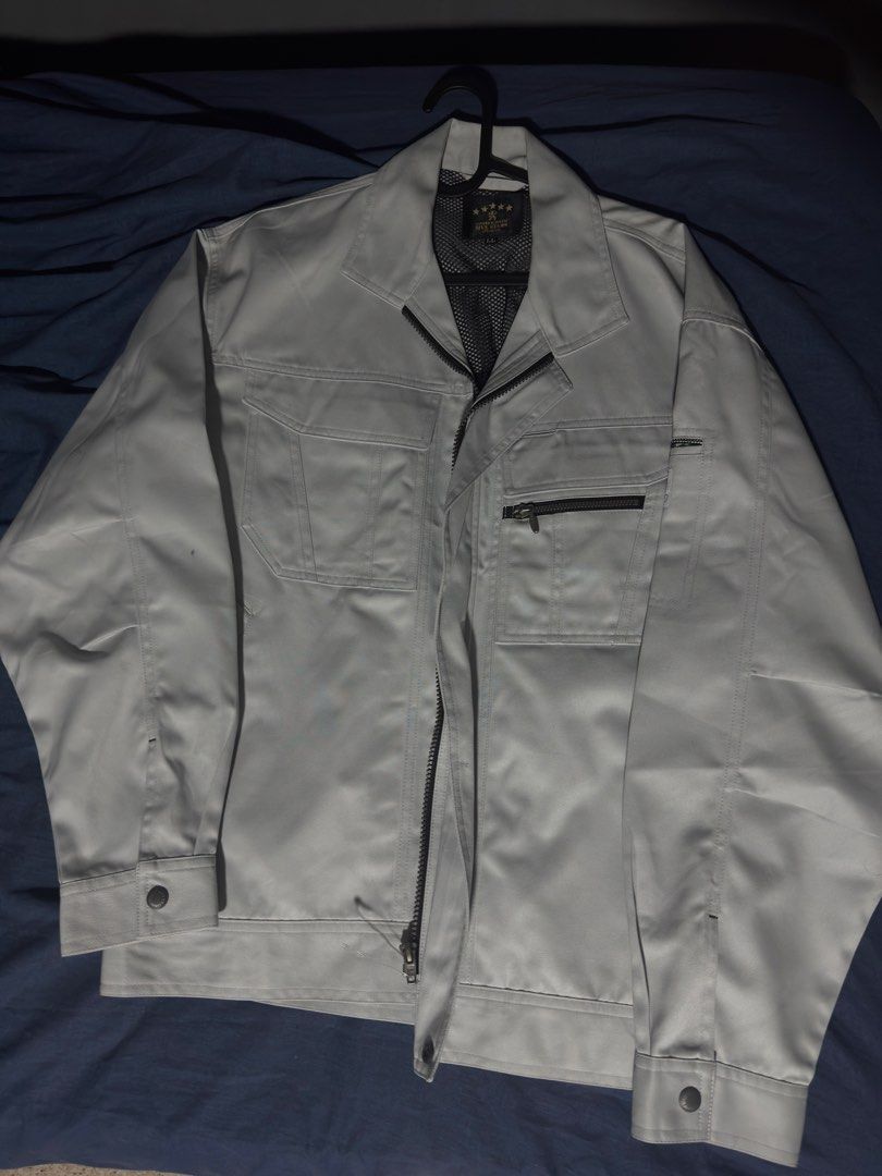 Work Jacket (Category: Coats, Jackets and Outerwear) located in Singapore. Submitted by rikhil.0 (Listing ID 1438990529, Image 1). Description: - Silver work jacket - Multiple pockets - Zip closure - Buttoned cuffs and collar - Suitable for work or casual wear.