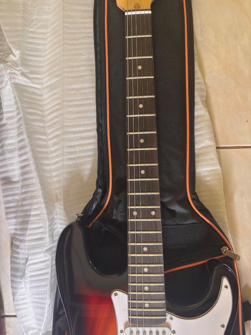 YIFENLI Electric Guitar with Case (Category: Musical Instruments) located in Caloocan City. Submitted by blackstar1019 (Listing ID 1438881003, Image 2). Description: 39 inch Electric Guitar ST Electric Guitar Telecaster w/ accesories - Sunburst finish - White pickguard - Three pickups - Tremolo bridge - Includes a black guitar case with orange trim - Comes with a cable - Brand new in original packaging.