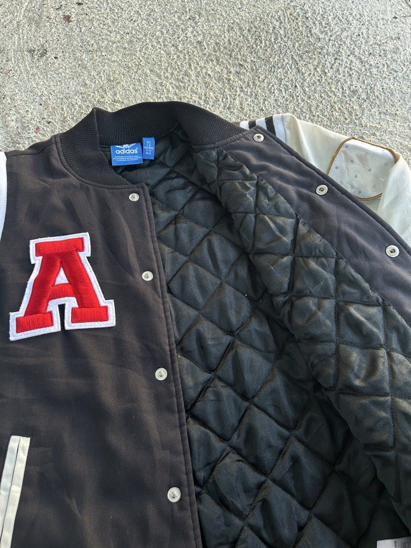 Adidas Varsity Jacket (Category: Coats, Jackets and Outerwear) located in Dasmarinas. Submitted by zn_upcldtrs (Listing ID 1439228260, Image 3). Description: - 20 W / 27 L - Adidas varsity jacket - Black body with cream sleeves - Adidas trefoil logo on front and back - Large red "A" patch - Additional patches on sleeves - Quilted black lining - Button-up front - Ribbed cuffs and hem.