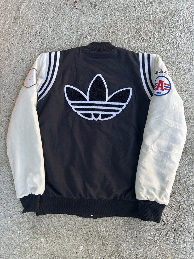 Adidas Varsity Jacket (Category: Coats, Jackets and Outerwear) located in Dasmarinas. Submitted by zn_upcldtrs (Listing ID 1439228260, Image 2). Description: - 20 W / 27 L - Adidas varsity jacket - Black body with cream sleeves - Adidas trefoil logo on front and back - Large red "A" patch - Additional patches on sleeves - Quilted black lining - Button-up front - Ribbed cuffs and hem.