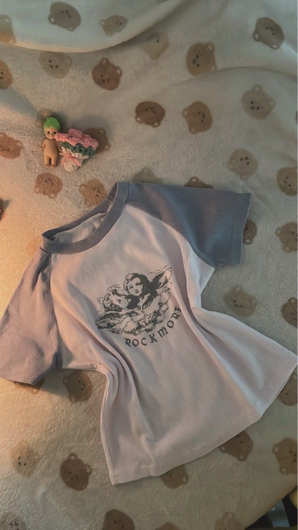 Angel Gray White Top (Category: Sleeveless) located in Makati City. Submitted by kzisdeclutter (Listing ID 1439245842, Image 2). Description: - Stylish angel gray and white top - Features an angel graphic and "ROCKMORE" text - Ribbed texture - Comfortable fit - Perfect for casual wear - Price: 100 pesos.