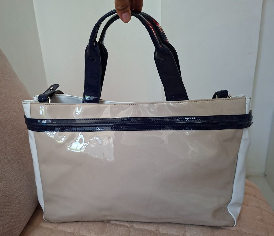 Armani Exchange Patent Tote Bag (Category: Luxury Bags & Wallets) located in Tuguegarao City. Submitted by thosphbys49295 (Listing ID 1439079044, Image 2). Description: - Armani Exchange tote bag - Beige and white patent finish - Navy blue shoulder strap and handles - Circular logo detail - Detachable shoulder strap.
