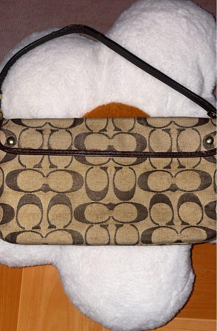 Authentic Coach Signature Turnlock Wristlet (Category: Purses & Pouches) located in Caloocan City. Submitted by ruby_welly22 (Listing ID 1439210279, Image 2). Description: Pre-loved. Canvas and interior are clean, leather strap is intact. Hardware has visible scratches/fading on the turnlock plate due to use (see photos), but it still locks perfectly. .