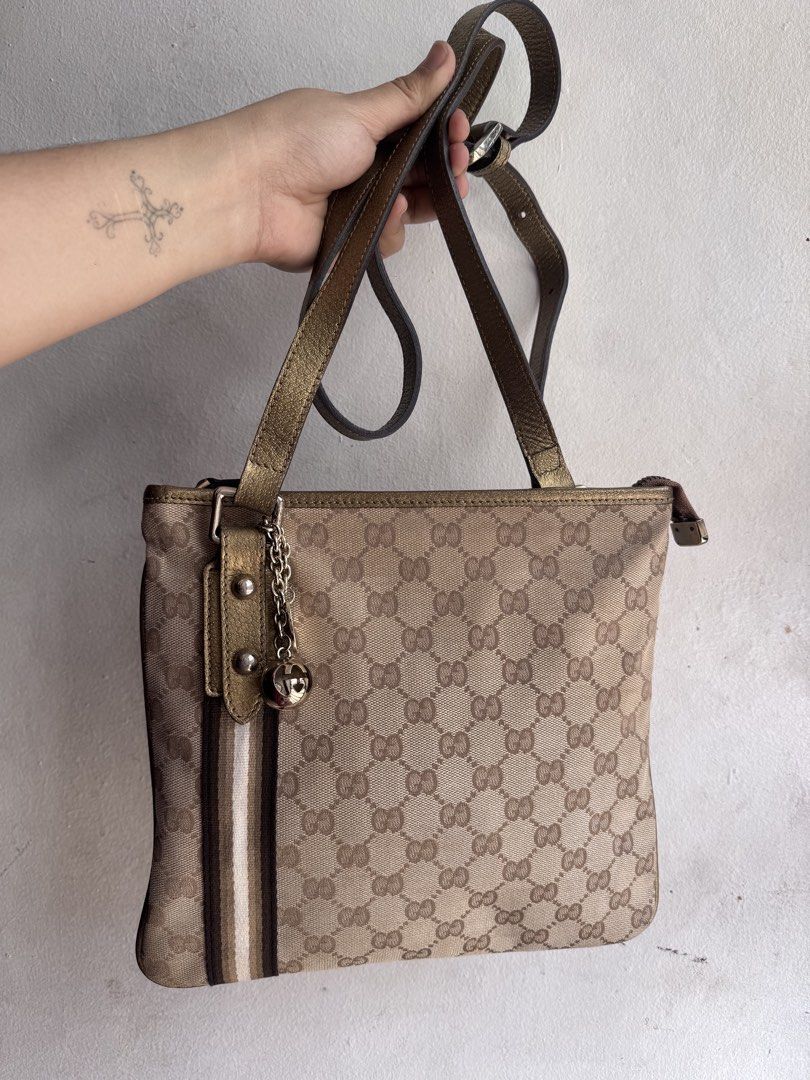 Authentic Gucci GG Canvas Crossbody Bag (Category: Luxury Bags & Wallets) located in Manila. Submitted by thriftyhaven2023 (Listing ID 1439118561, Image 3). Description: 8/10 Condition - Authentic Gucci shoulder bag - Iconic GG canvas - Gold-toned shoulder strap and hardware - Vertical stripe detail - Includes charm with ball pendant NO FLAWS Has minimal normal signs of usage only..