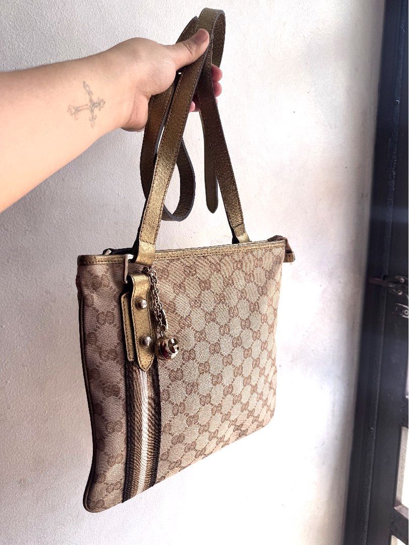 Authentic Gucci GG Canvas Crossbody Bag (Category: Luxury Bags & Wallets) located in Manila. Submitted by thriftyhaven2023 (Listing ID 1439118561, Image 1). Description: 8/10 Condition - Authentic Gucci shoulder bag - Iconic GG canvas - Gold-toned shoulder strap and hardware - Vertical stripe detail - Includes charm with ball pendant NO FLAWS Has minimal normal signs of usage only..