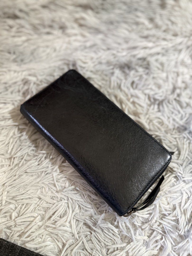 Balenciaga Black Leather Wallet (Category: Luxury Bags & Wallets) located in Binan City. Submitted by jgca01 (Listing ID 1439086650, Image 2). Description: - Guranteed orig Black leather wallet - Zip closure - Multiple compartments and card slots - Includes wrist strap - Textured leather exterior - Brass-colored hardware - money back if proven fake by authorized authenticator.
