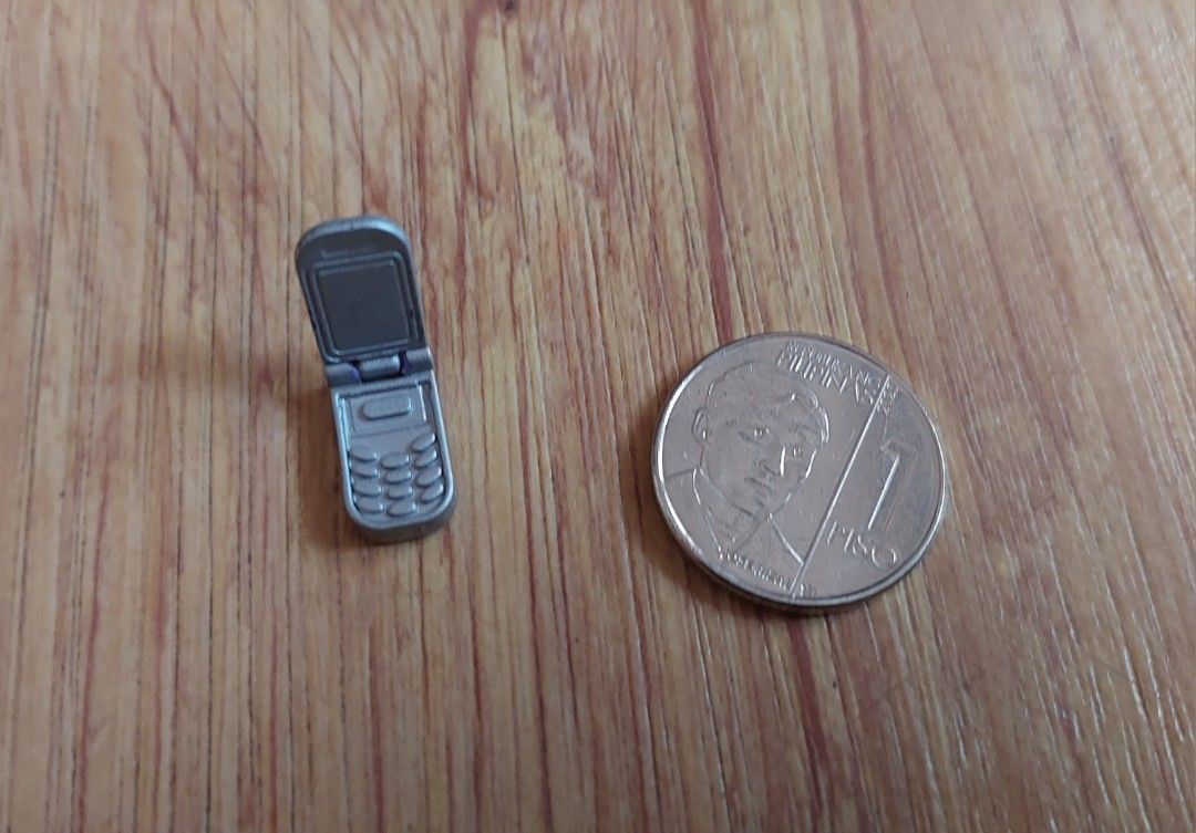 Barbie Flip Phone Vintage (Category: Early Generation Mobile Phones) located in Manila. Submitted by tsinelasni55674 (Listing ID 1439160253, Image 2). Description: Barbie silver flip phone Mattel Collectible Small size, shown with 1 Piso coin for scale For further inquiries feel free to welcome us your message about the item.🙆 Kindly imit your expectation since the item is preloved. except from new oldstock. Shipping Fee: care of buyers via Grab