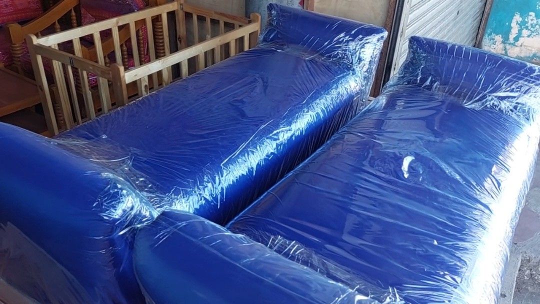 Blue Sofa with Armrests (Category: Sofas) located in San Jose del Monte. Submitted by ms.key (Listing ID 1439099164, Image 2). Description: - Two-seater blue sofa - Features armrests - Modern, low-profile design - Comfortable cushions - Wrapped in protective plastic - Set on a wooden base.