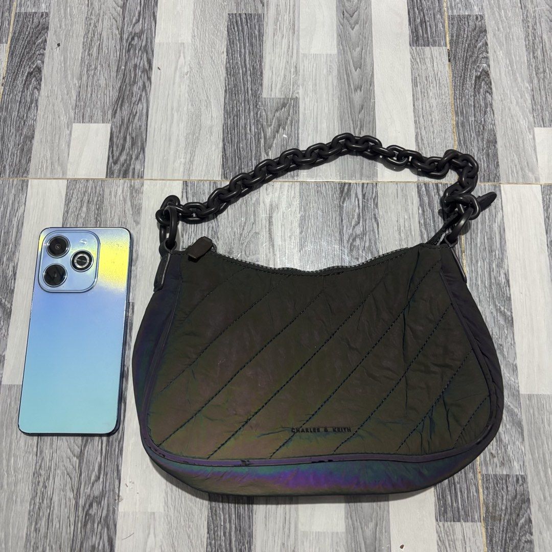 Charles & Keith Quilted Shoulder Bag (Category: Shoulder Bags) located in Banga. Submitted by akosiloco (Listing ID 1439079976, Image 2). Description: - Charles & Keith shoulder bag - Quilted design with iridescent finish - Chain strap and long strap included - Main compartment with interior pockets - Secure zipper closure - Authentic Charles & Keith label inside.