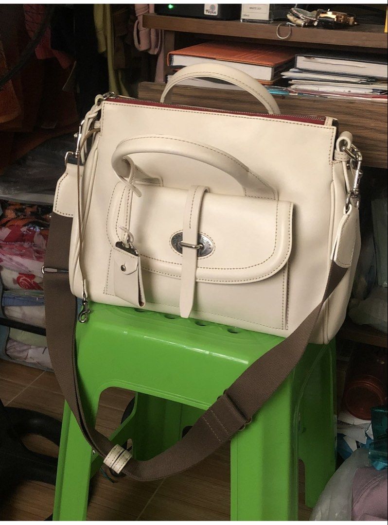 Cream Leather Handbag with Shoulder Strap (Category: Shoulder Bags) located in Quezon City. Submitted by cprmob (Listing ID 1439122014, Image 3). Description: - Cream-colored leather handbag - Top handle and detachable shoulder strap - Front flap pocket with buckle closure - Includes a small leather tag - Red interior lining - Comes with dust bag.