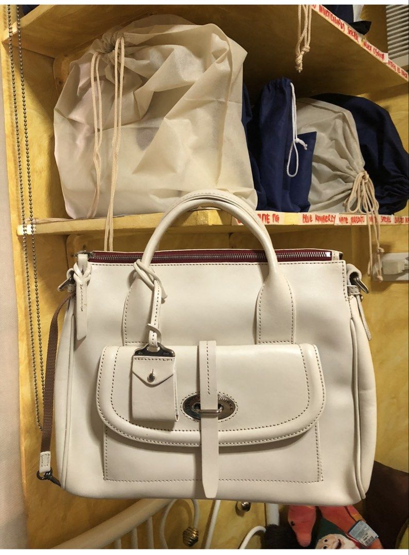 Cream Leather Handbag with Shoulder Strap (Category: Shoulder Bags) located in Quezon City. Submitted by cprmob (Listing ID 1439122014, Image 1). Description: - Cream-colored leather handbag - Top handle and detachable shoulder strap - Front flap pocket with buckle closure - Includes a small leather tag - Red interior lining - Comes with dust bag.