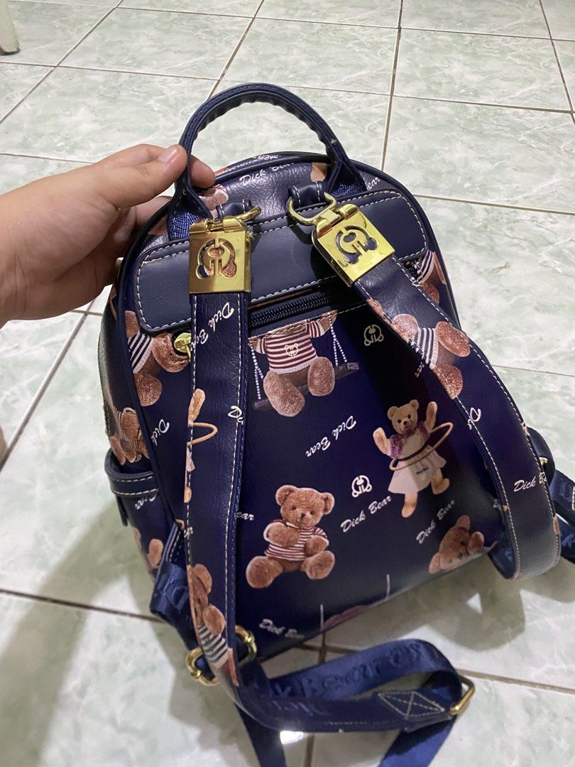 Dick Bear Teddy Bear Backpack (Category: Backpacks) located in Valenzuela. Submitted by lotbi (Listing ID 1439113660, Image 2). Description: - Navy blue backpack with adorable teddy bear print - Stylish gold-colored stud accents - Comfortable top handle and adjustable straps - Spacious interior with multiple compartments - Features a chic brown lining - Branded "Dick Bear" design on front and inside.