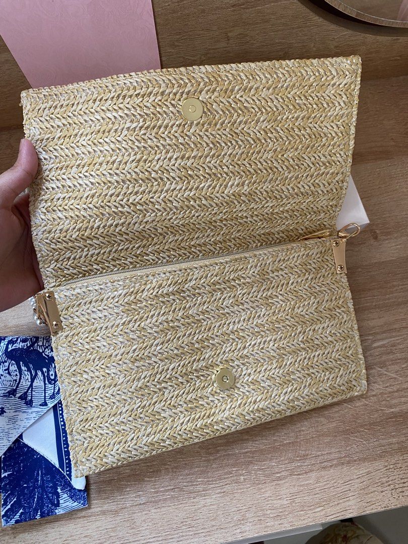 Dior Straw Clutch with Pearl Strap (Category: Luxury Bags & Wallets) located in Manila. Submitted by frish_2525 (Listing ID 1439123934, Image 3). Description: - Authentic Dior clutch - Woven straw exterior - Embroidered Dior logo - Detachable pearl strap - Includes matching box - Interior: zippered compartment and fabric lining - Comes with a small blue and white patterned accessory.
