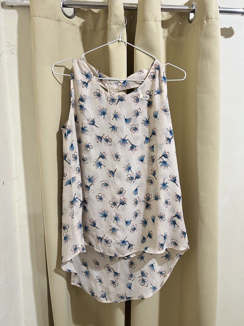 Floral Sleeveless Top (Category: Sleeveless) located in Manila. Submitted by decluttr.corner (Listing ID 1439141361, Image 1). Description: - Floral sleeveless top - Unique cut-out back design with button details - V-neckline - Curved hem - White with blue and black floral pattern - Lightweight and flowy fabric - Ideal for warm weather.