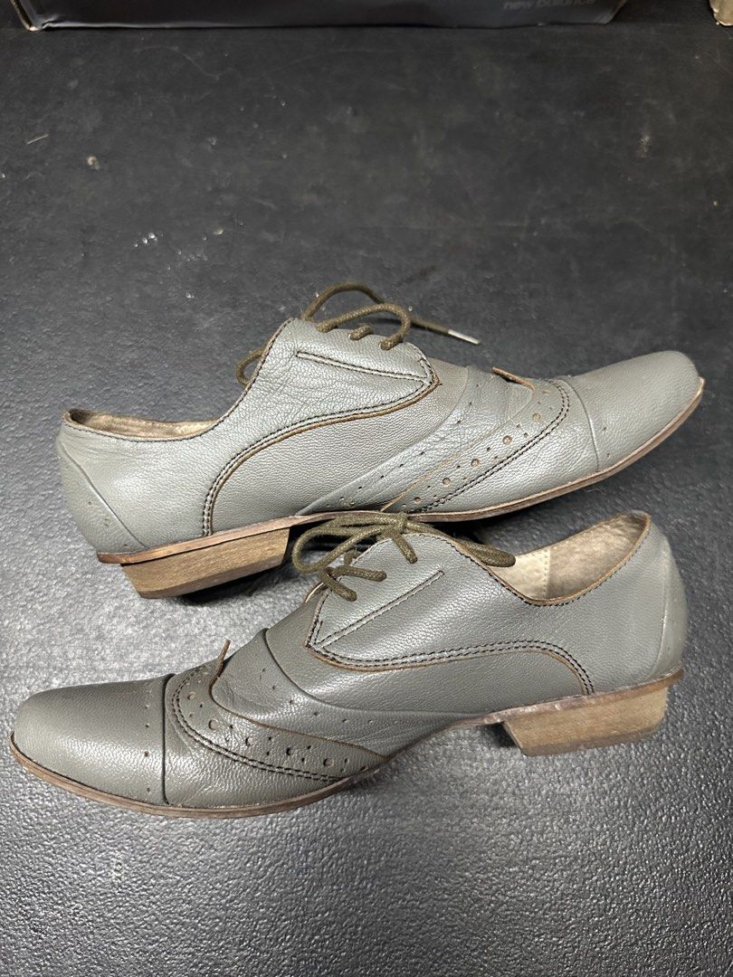 Grey Leather Oxford Shoes (Category: Casual Shoes) located in Quezon City. Submitted by plzdeclutter (Listing ID 1439216958, Image 1). Description: - Grey leather wingtip oxford shoes - Lace-up closure - Classic wingtip design with decorative perforations - Low heel - Textured sole - Dark green laces - Visible interior lining - Well-worn condition -Size 5 W.