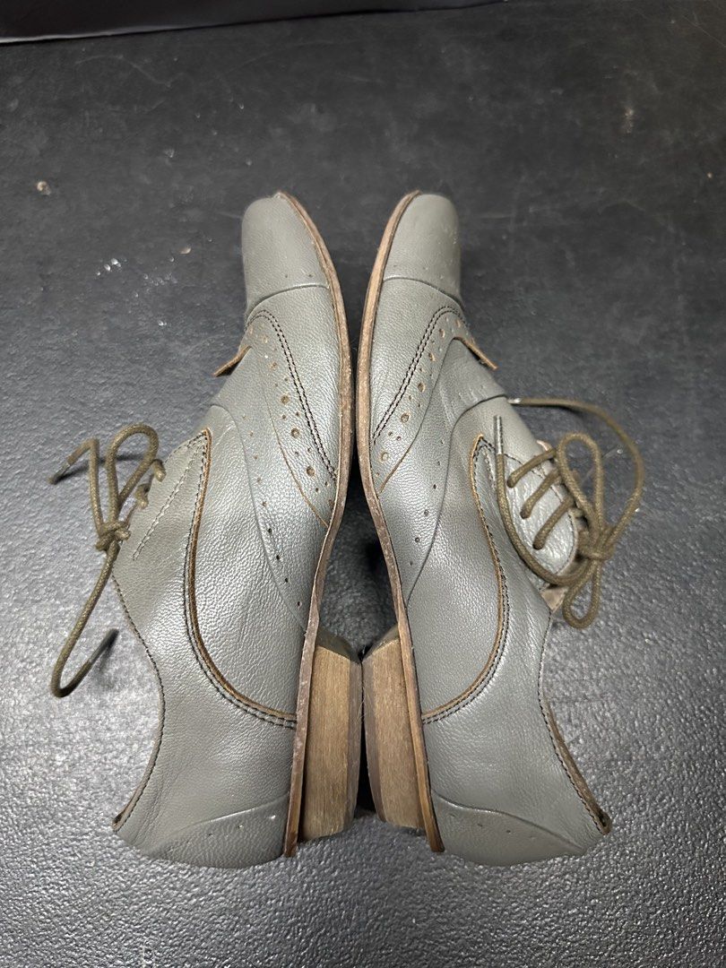 Grey Leather Oxford Shoes (Category: Casual Shoes) located in Quezon City. Submitted by plzdeclutter (Listing ID 1439216958, Image 3). Description: - Grey leather wingtip oxford shoes - Lace-up closure - Classic wingtip design with decorative perforations - Low heel - Textured sole - Dark green laces - Visible interior lining - Well-worn condition -Size 5 W.