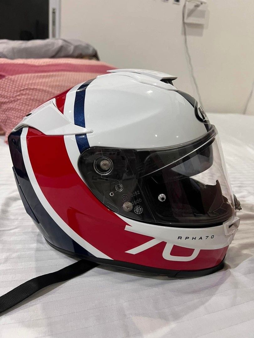HJC RPHA 70 Motorcycle Helmet (Category: Helmets and other Riding Gears) located in Alaminos. Submitted by osaj55756 (Listing ID 1439095088, Image 3). Description: original - HJC RPHA 70 motorcycle helmet - Color: White, red, and blue - Includes clear visor - Includes dark visor - RPHA 70 model visible - Features a secure strap.