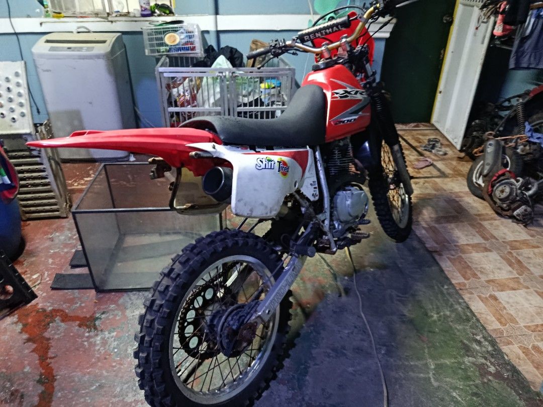 Honda XR Motorcycle (Category: Motorbikes for Sale) located in Caloocan City. Submitted by florespatrickjohntbk (Listing ID 1439081403, Image 1). Description: Honda XR motorcycle with red and white body. Features a black seat and off-road tires. Includes a red front fairing and a custom exhaust. The bike is suitable for off-road adventures..