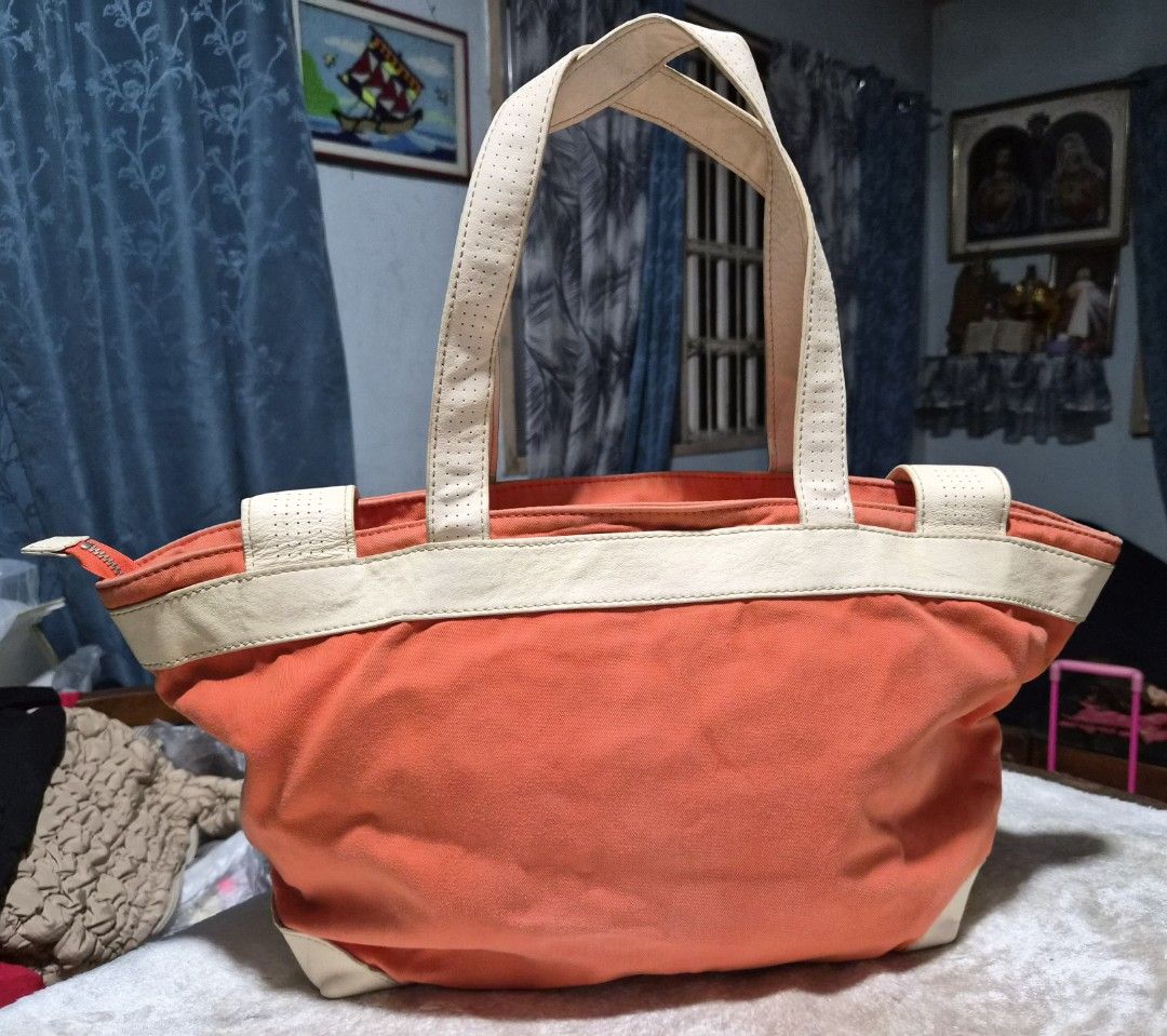 Lacoste Orange Canvas/Leather Tote Bag (Category: Office & Business Technology) located in Mandaue City. Submitted by chuchi152615 (Listing ID 1439090962, Image 2). Description: - Orange Lacoste tote bag - Cream-colored accents and handles - Features a small front pocket - Spacious interior - Durable, canvas-like material - Perforated handles - Suitable for everyday use.