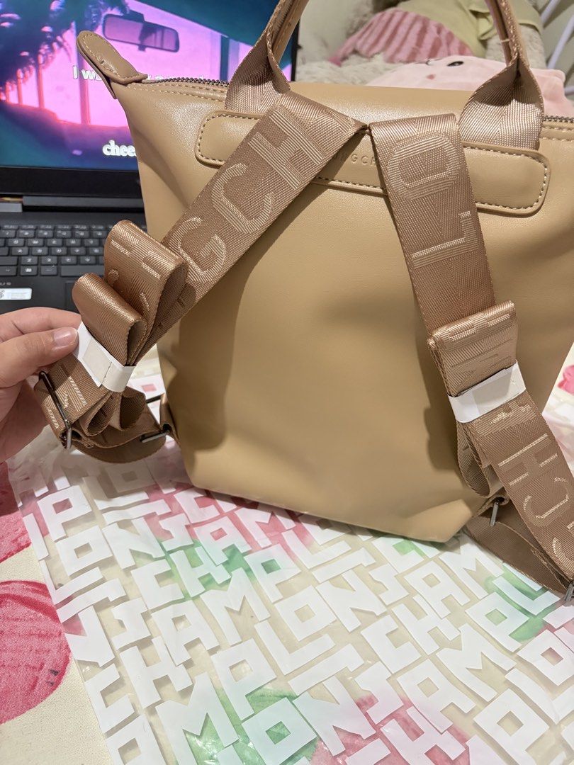 Longchamp Le Pliage Backpack (Category: Luxury Bags & Wallets) located in Manila. Submitted by axchichaaa (Listing ID 1439120910, Image 2). Description: - Authentic Longchamp Le Pliage Backpack - Color: Tan - Features: - Top handle - Adjustable straps - Zippered closure - Flap with snap closure - Interior: - Lined - Small pocket - Longchamp logo detail.