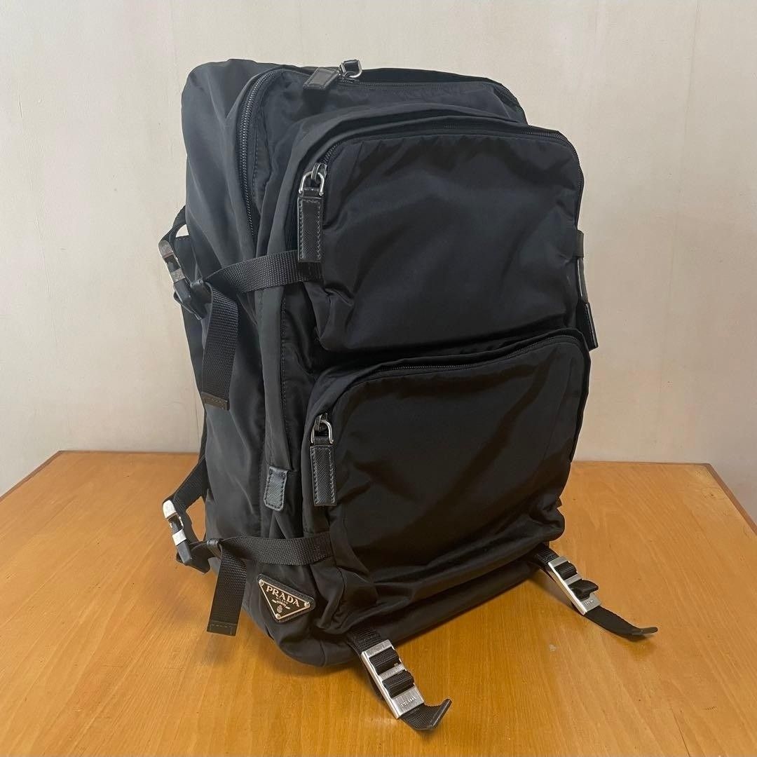 Prada Black Nylon Backpack (Category: Luxury Bags & Wallets) located in Pasig City. Submitted by yoyosstore (Listing ID 1439077136, Image 2). Description: - Authentic Prada backpack - Multiple compartments for storage - Top handle and adjustable straps - Prada logo on the side and inside - Interior zippered pocket - Buckle closures on sides and bottom - Minor wear on handle due to storage - No tear or damage. Very good condition, RFS decluttering