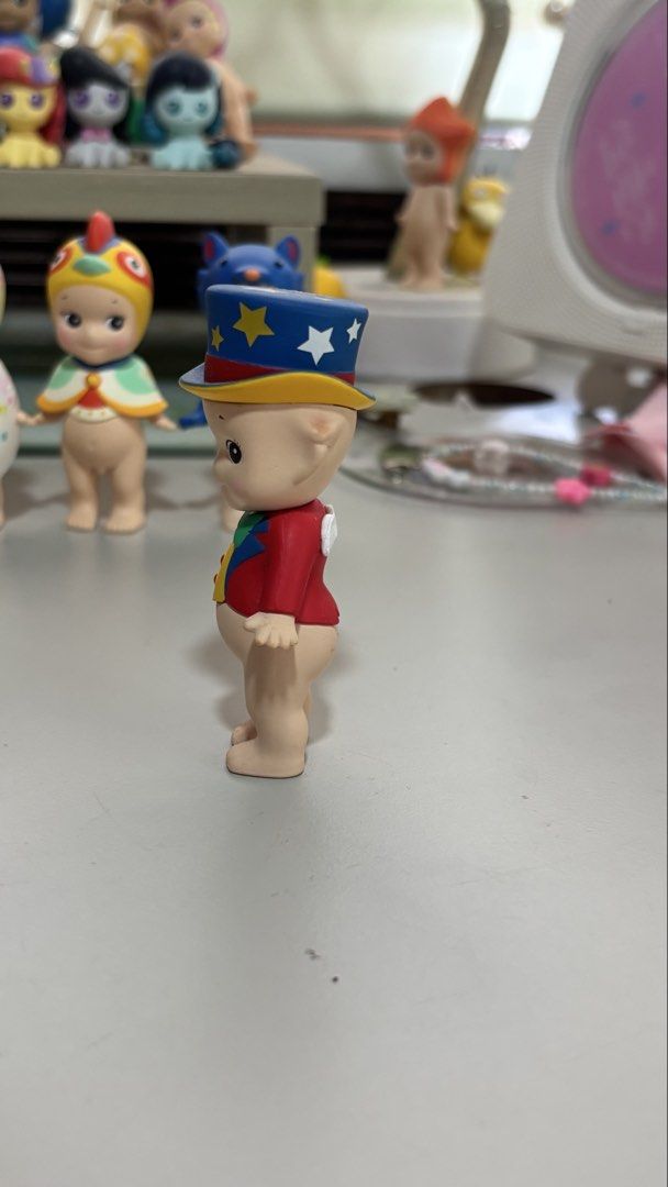 Sonny Angel Circus Series Figurine (Category: Designer & Blind Box Toys) located in Manila. Submitted by obusanrick04115 (Listing ID 1439098105, Image 2). Description: - Adorable Sonny Angel figurine from the Circus series. - Features a charming design. - Red jacket and a blue top hat with stars. - Colorful vest. - Small white wings on the back. - Perfect for collectors or decoration..