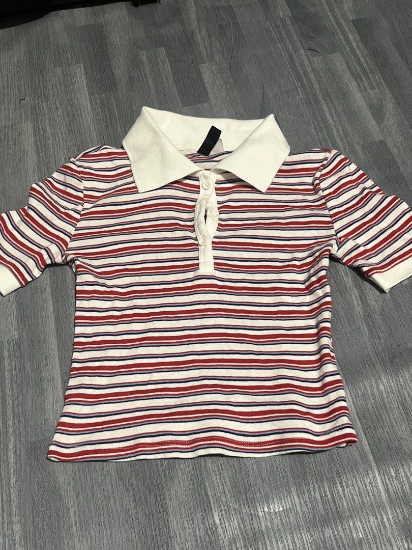 Striped Polo Shirt H&M (Category: Shirts) located in Manila. Submitted by liaaa89 (Listing ID 1439186243, Image 1). Description: - Classic striped polo shirt - Red and blue stripes on white background - White collar - Button-up front - Short sleeves - Fitted silhouette - Versatile for various occasions.