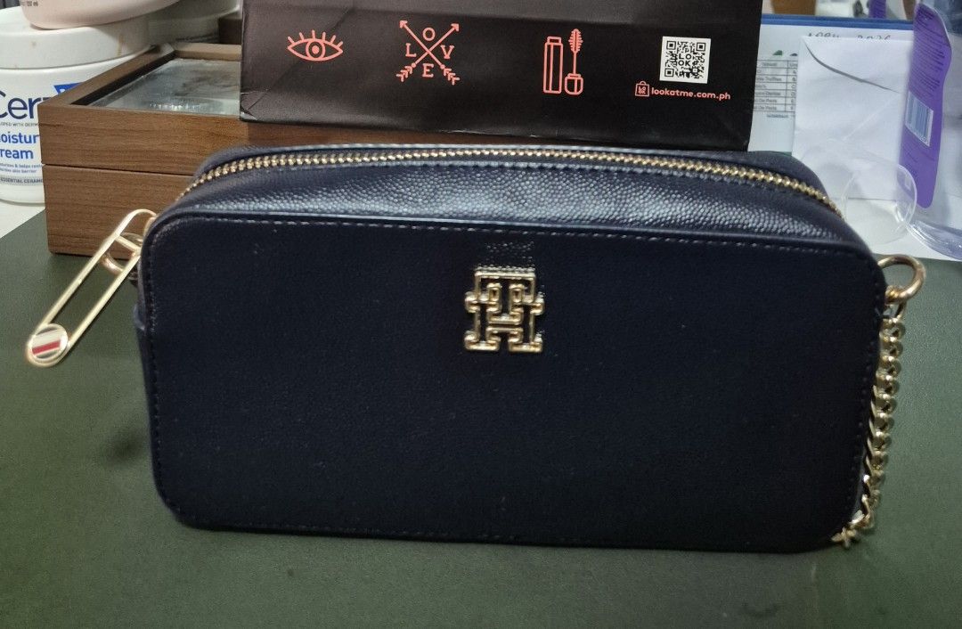 Tommy Hilfiger shoulder Bag authentic (Category: Cross-body Bags) located in Manila. Submitted by sorayabarr50152 (Listing ID 1439082966, Image 2). Description: - Tommy Hilfiger crossbody bag - Navy blue color - Gold-tone chain strap - Gold-tone logo detail - Secure zip closure - Crafted from leather - Ideal size for carrying essentials.
