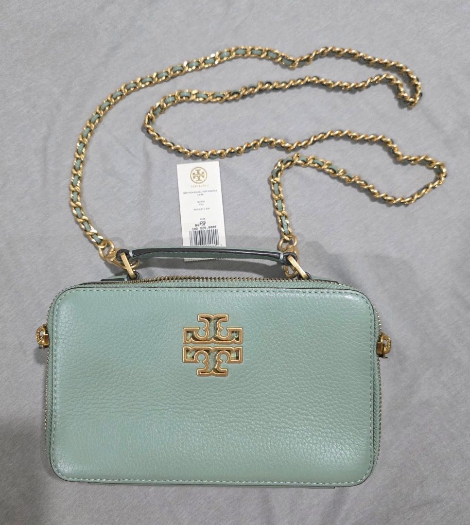 Tory Burch Britten Small Top Handle Bag (Category: Luxury Bags & Wallets) located in Iloilo. Submitted by kariz0314 (Listing ID 1439112321, Image 1). Description: Product Highlights Collection: BrittenMaterial: Pebbled leather with gold-tone hardware Features: A structured silhouette with a top handle and a detachable chain-and-leather crossbody strap. Dimensions: Approximately 8" L x 4.5" H x 2.5" D..