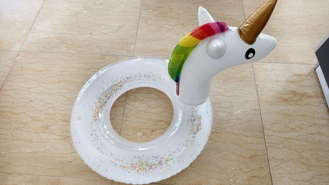Unicorn Inflatable Pool Float (Category: Water Sports) located in Kuala Lumpur. Submitted by lihuateh (Listing ID 1439137775, Image 1). Description: - Unicorn-shaped inflatable pool float - Features a white body with colorful glitter accents - Rainbow mane and gold horn - Designed with a friendly expression - Ideal for pool and beach enjoyment.