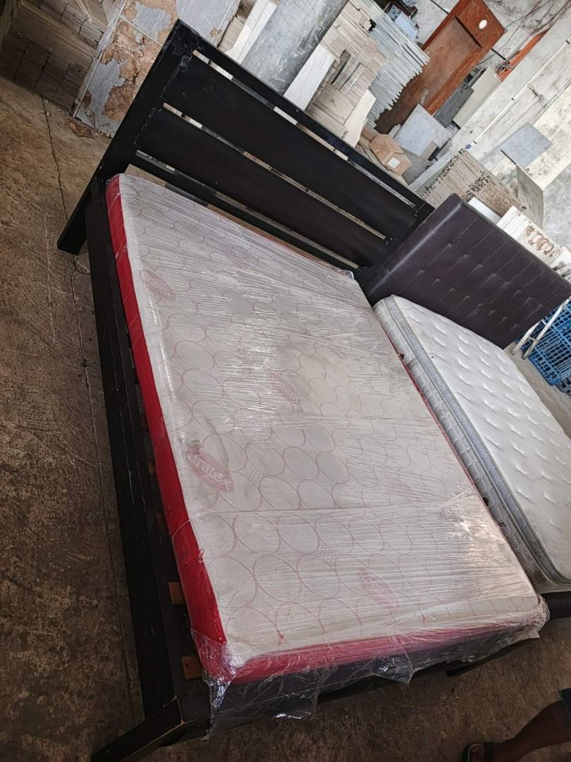Wooden Bed Frame with Mattress (Category: Bed Frames & Mattresses) located in San Pedro. Submitted by cgi.saversplustrading (Listing ID 1439083204, Image 2). Description: - Black wooden bed frame - Includes mattress (wrapped in plastic) - Unique headboard design - Sturdy and well-built construction - Ideal for bedroom use.